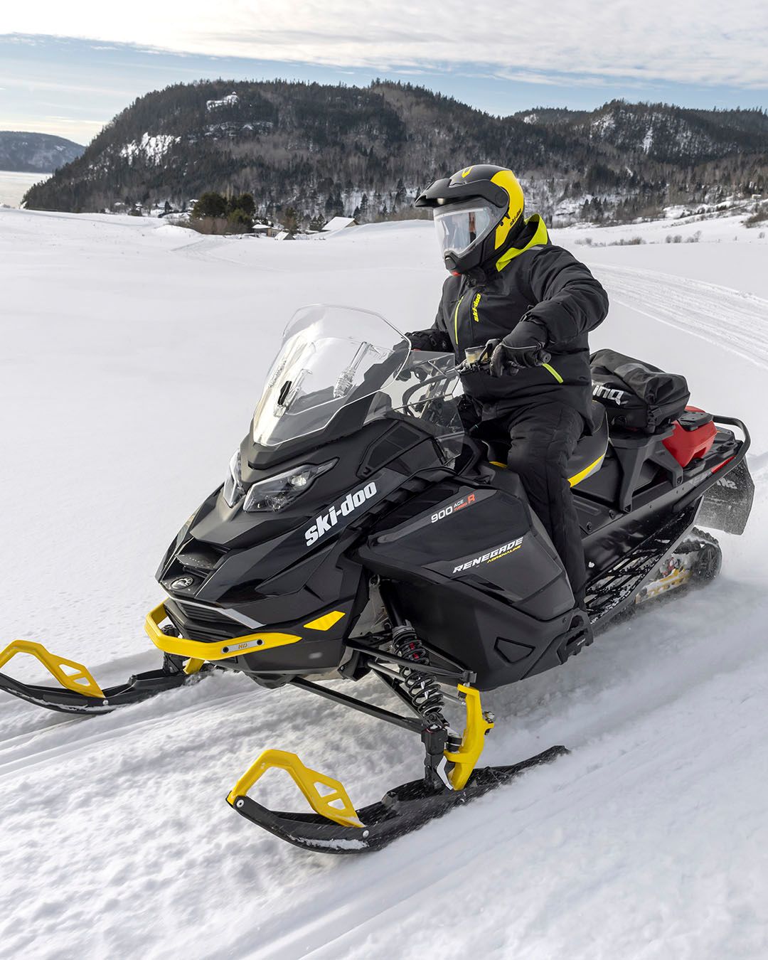 A Person Riding A Snowmobile On A Snowy Surface